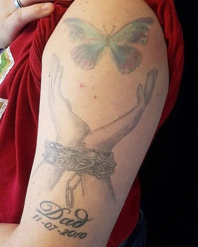 Tattoo of two hands with a chain around the wrist.